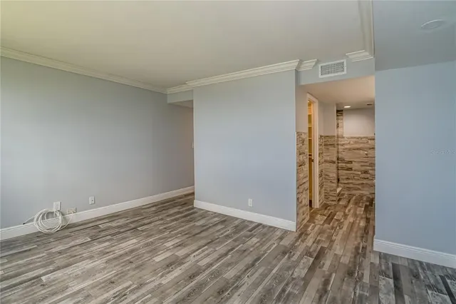 a view of empty room with wooden floor