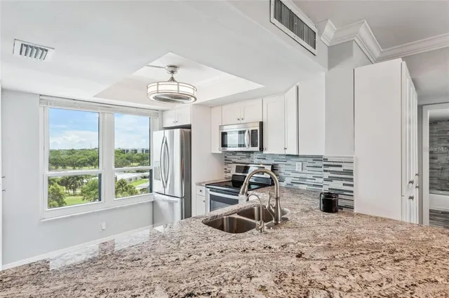 a kitchen with stainless steel appliances a stove a sink and a refrigerator