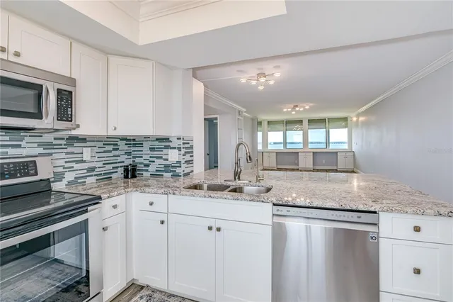 a kitchen with stainless steel appliances granite countertop a sink stove and cabinets