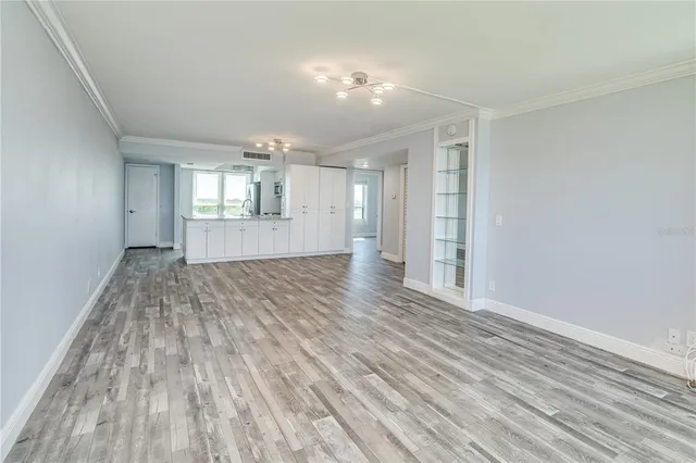 a view of empty room with wooden floor and window