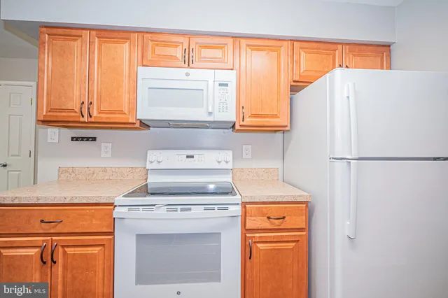a kitchen with stainless steel appliances granite countertop a sink and a white cabinets