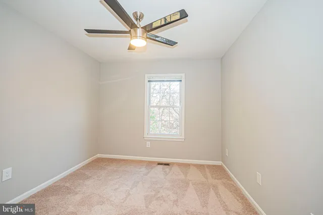 an empty room with chandelier fan