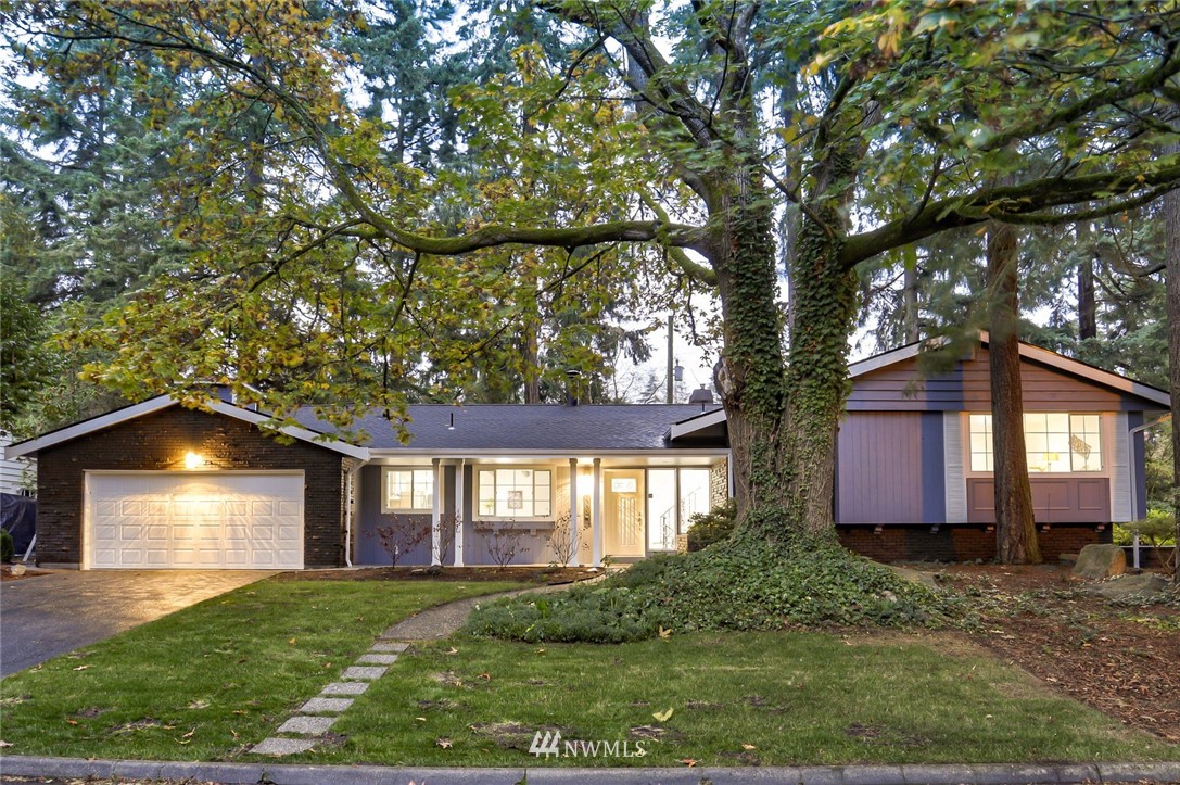 a front view of a house with a yard and a garden