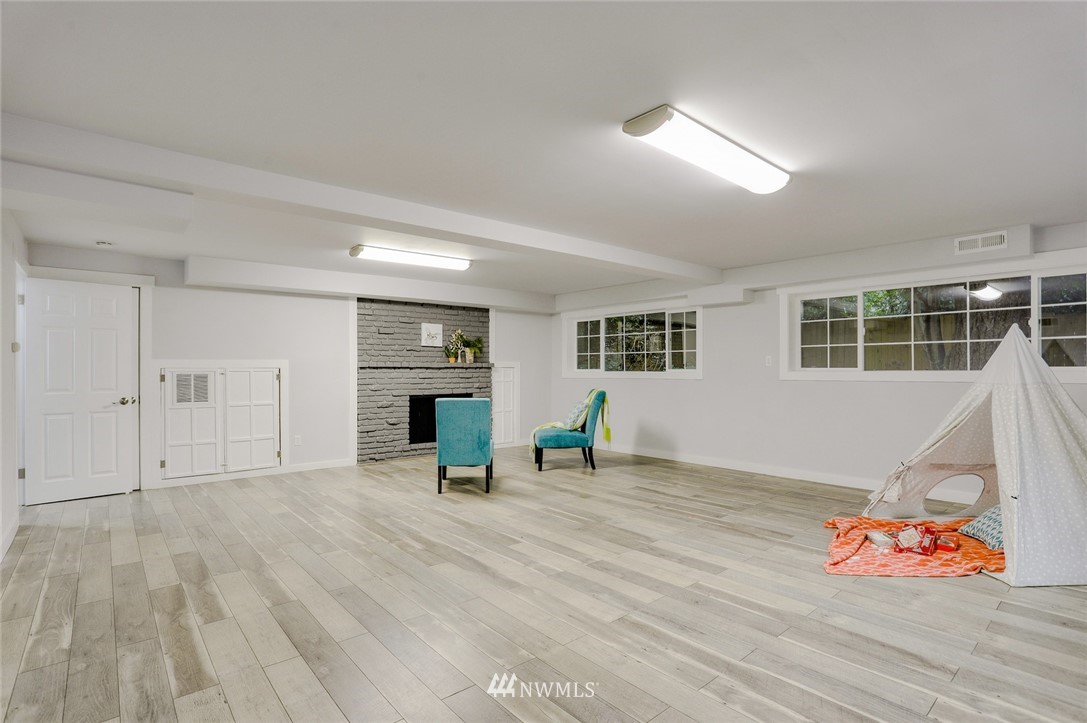 13534 Sherman Road Northwest Seattle, WA 98177 - Photo 11 of 20 a view of empty room with wooden floor and fireplace