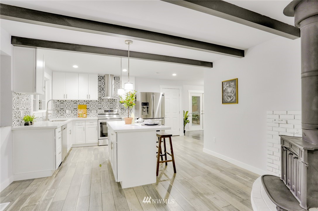 13534 Sherman Road Northwest Seattle, WA 98177 - Photo 8 of 20 a kitchen with white cabinets and chairs