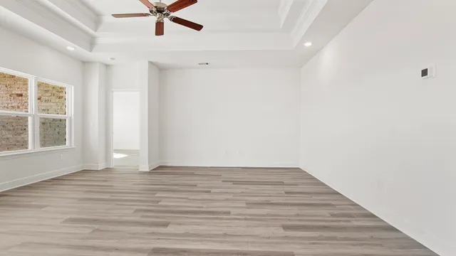 an empty room with wooden floor and entrance
