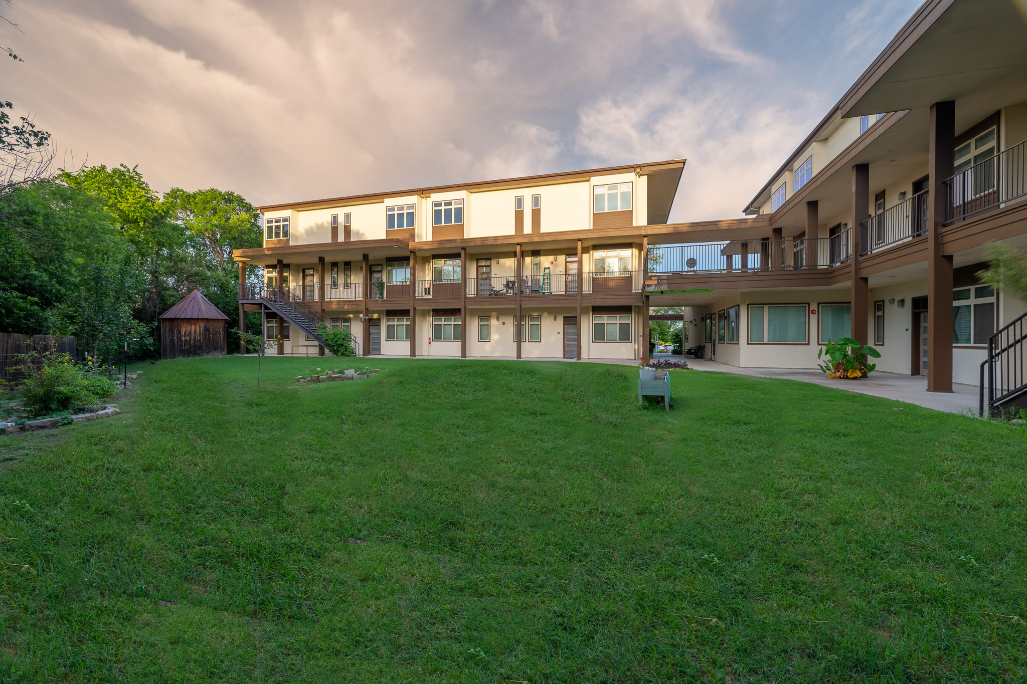 6700 Menchaca Road, Unit 20 Austin, TX 78745 - Photo 2 of 20 A verdant lawn graces the multi-story structure with private balconies and a unique connected walkway.