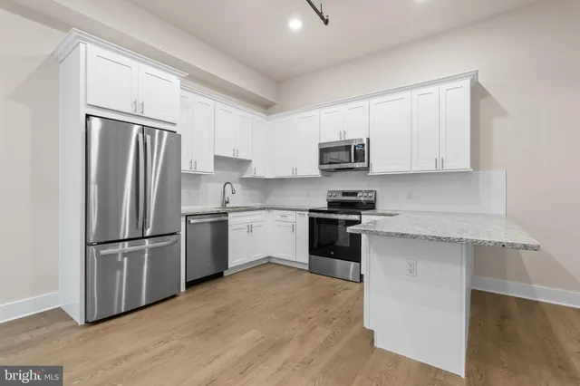 a kitchen with a refrigerator stove top oven and sink