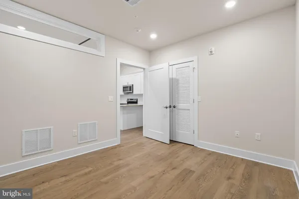a view of empty room with wooden floor and cabinet