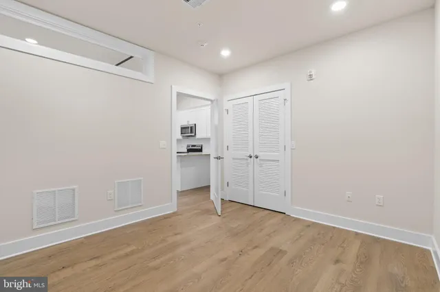 a view of empty room with wooden floor
