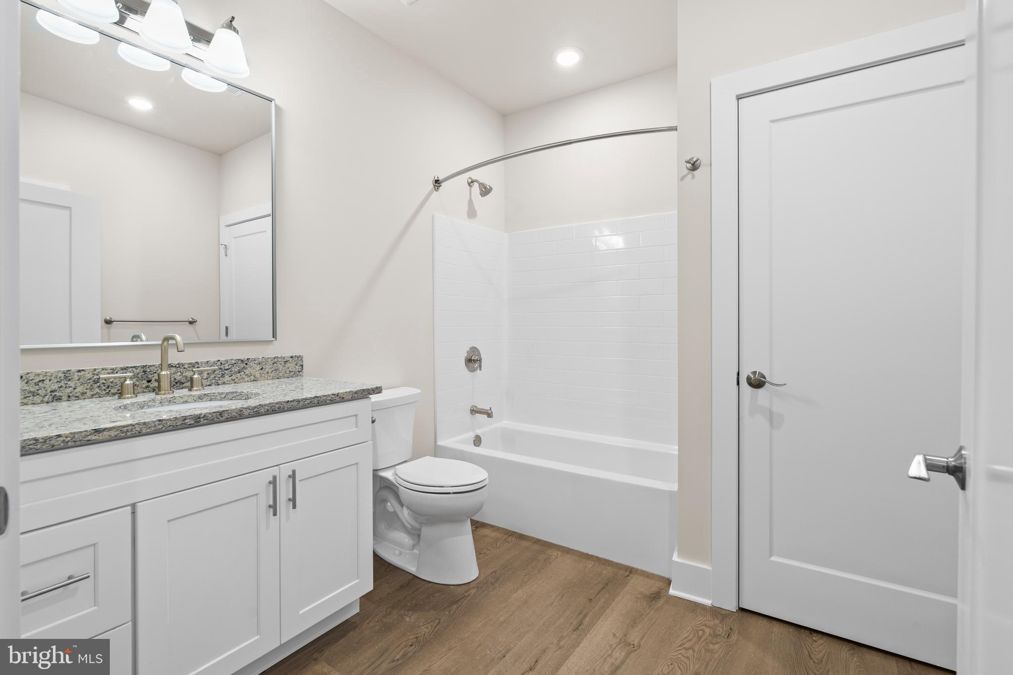 30 West Broad Street Souderton, PA 18964 - Photo 4 of 34 a bathroom with a granite countertop sink toilet a large mirror a bathtub and shower