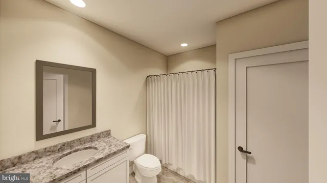 a bathroom with a granite countertop sink toilet and shower
