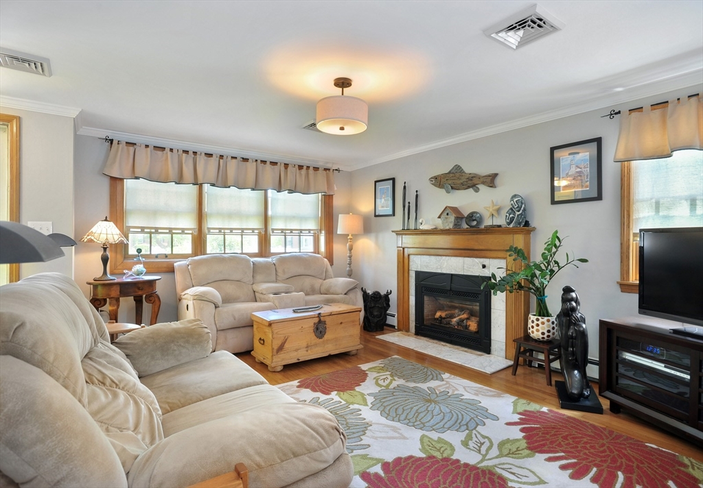 27 Atlantic House Road Hull, MA 02045 - Photo 11 of 30 a living room with furniture a fireplace and a flat screen tv