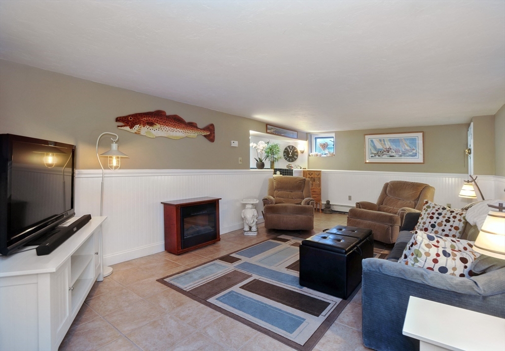 27 Atlantic House Road Hull, MA 02045 - Photo 23 of 30 a living room with furniture a flat screen tv and a fireplace