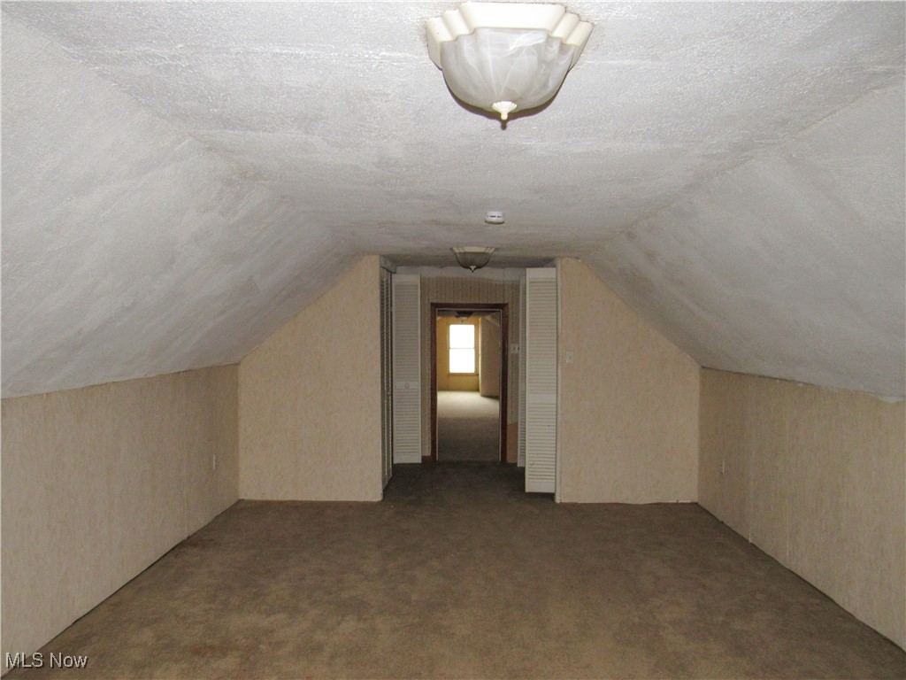 2218 Lake Road Akron, OH 44312 - Photo 14 of 20 Bonus room with lofted ceiling, carpet flooring, and a textured ceiling
