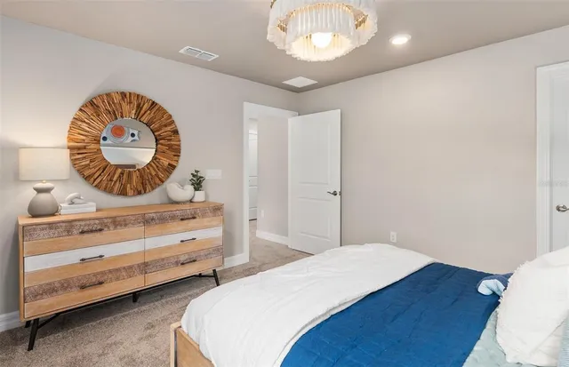 a bedroom with bed and a chandelier