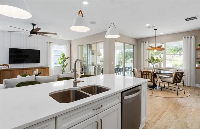 a kitchen with a sink a counter top space and living room view