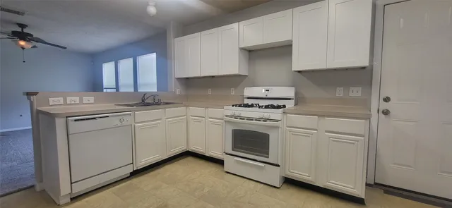 a kitchen with white cabinets and white appliances