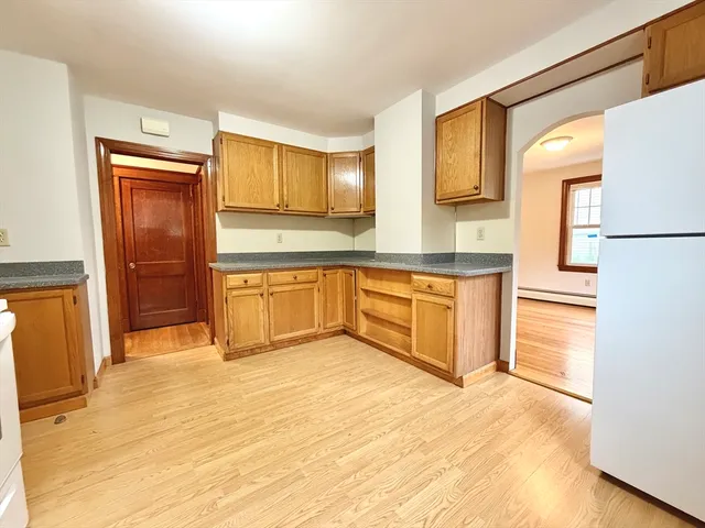 a large kitchen with stainless steel appliances granite countertop a refrigerator and a sink