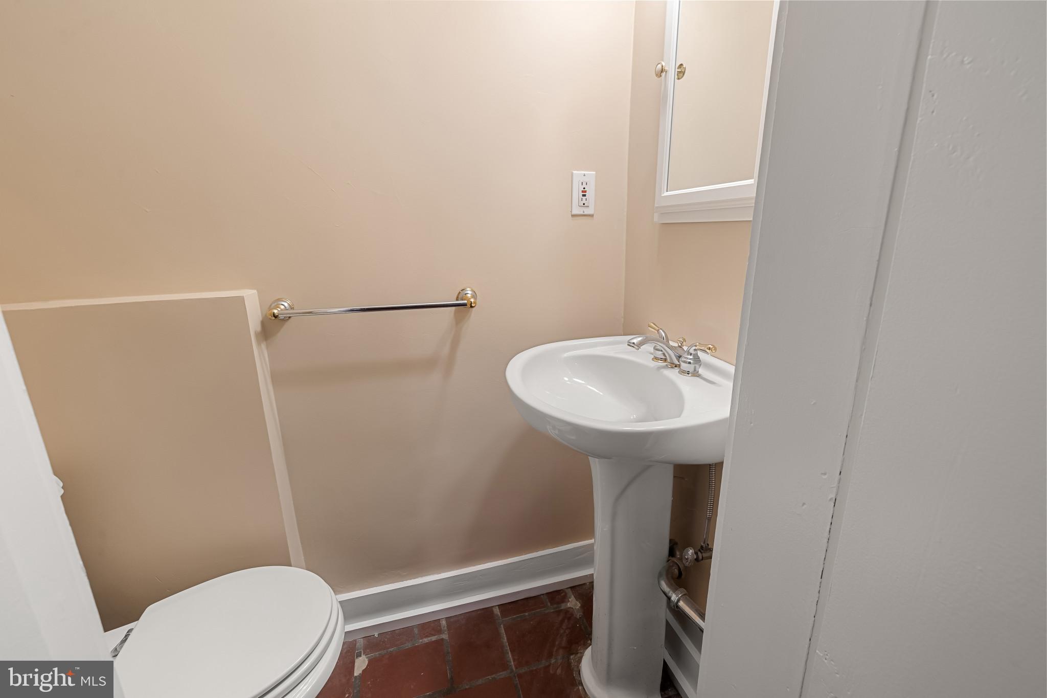 302 Tunbridge Road Baltimore, MD 21212 - Photo 41 of 77 a bathroom with a sink toilet and a mirror