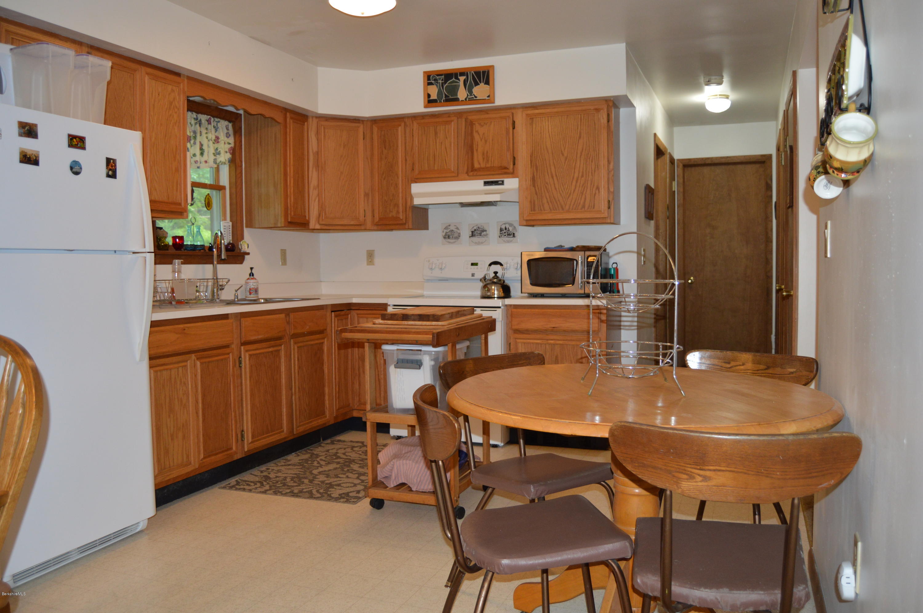 2965 Hancock Road Hancock, MA 01267 - Photo 8 of 33 a kitchen with stainless steel appliances a dining table chairs refrigerator and sink