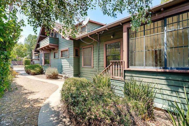 a view of house with wooden deck and furniture
