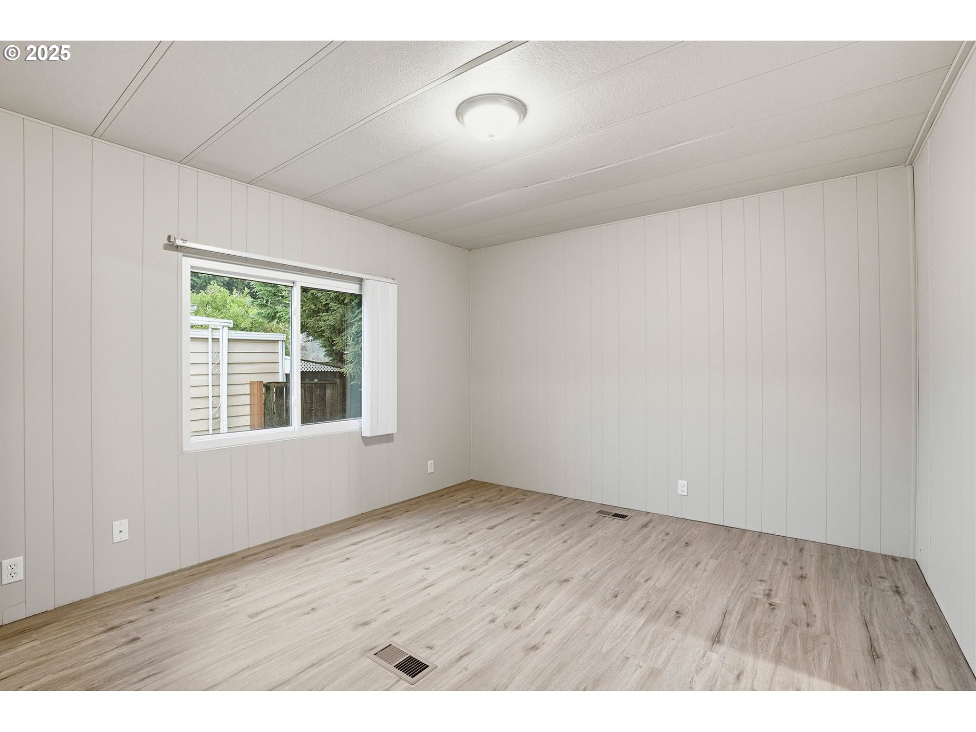 21100 Northeast Sandy Boulevard, Unit 59 Fairview, OR 97024 - Photo 6 of 16 a view of an empty room with wooden floor and a window
