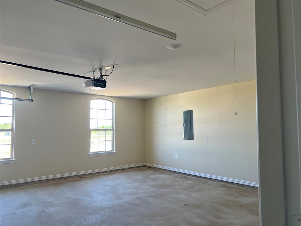 8008 County Road 1058 Rice, TX 75155 - Photo 24 of 25 Spacious garage featuring two arched windows, a concrete floor, high ceilings, and a garage door opener system