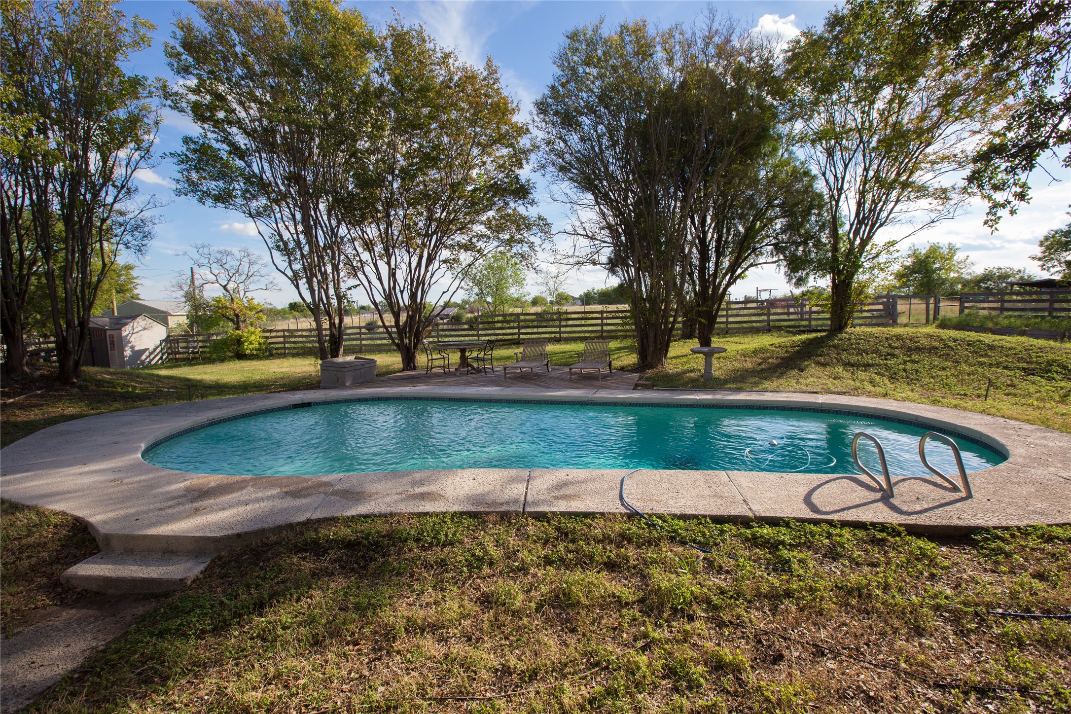 3517 Gattis School Road Round Rock, TX 78664 - Photo 11 of 16 An inviting in-ground pool offers tranquil relaxation amidst natural surroundings and a distant fence.