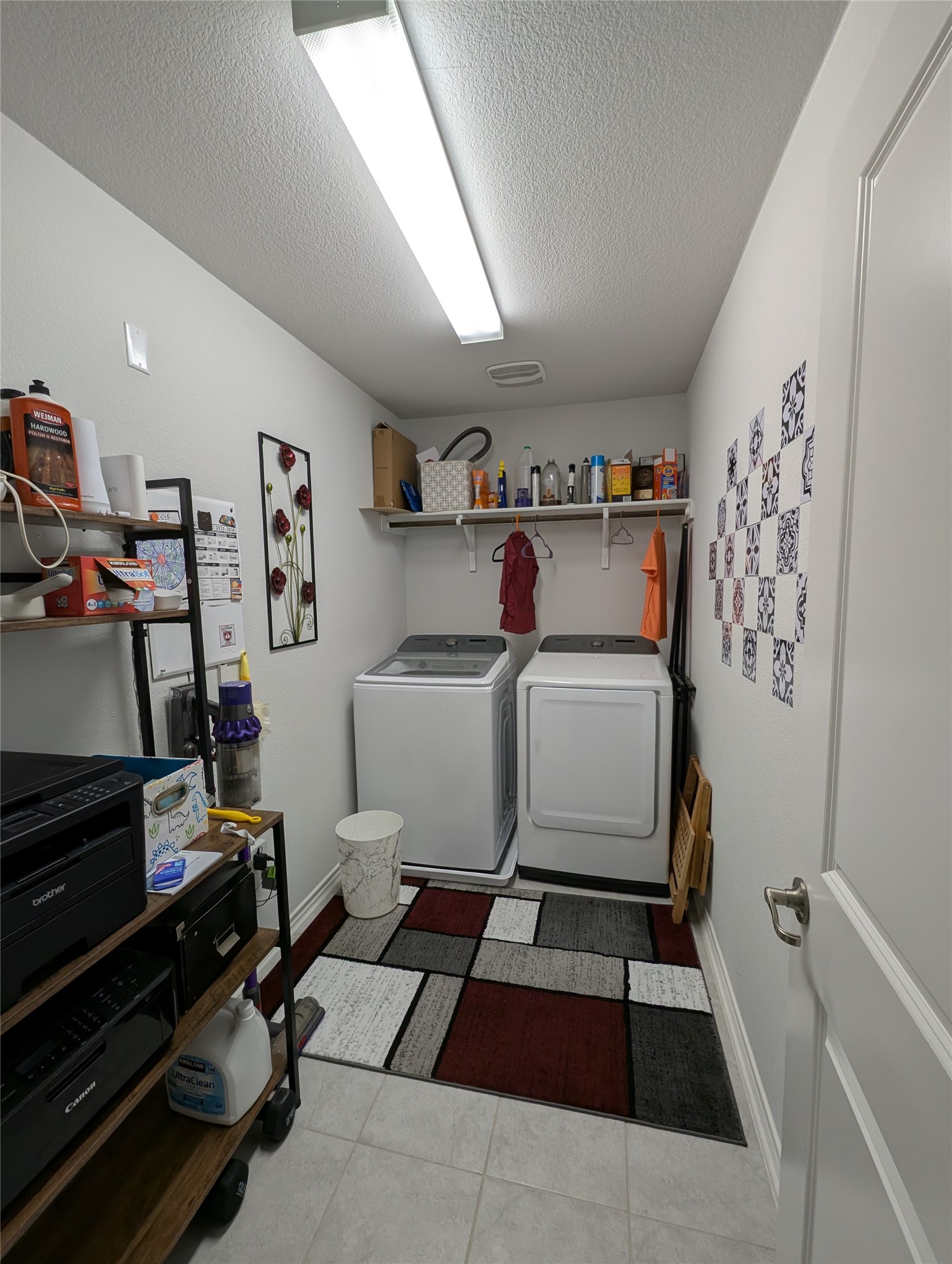 14502 McCoy Loop Austin, TX 78717 - Photo 16 of 26 Dedicated utility room featuring tile flooring, a wall-mounted shelf, and a clothing rod
