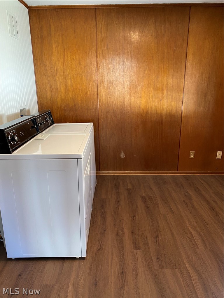 14549 Cedar Road Cleveland, OH 44121 - Photo 8 of 23 Clothes washing area with wooden walls, washing machine and dryer, and dark hardwood / wood-style floors