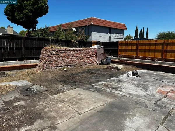 a view of a patio with table and chairs with wooden fence