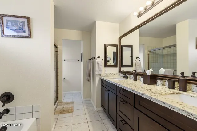 a spacious bathroom with a granite countertop sink and a mirror