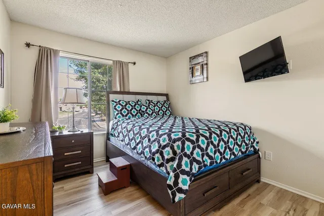 a bedroom with a bed window and a flat screen tv