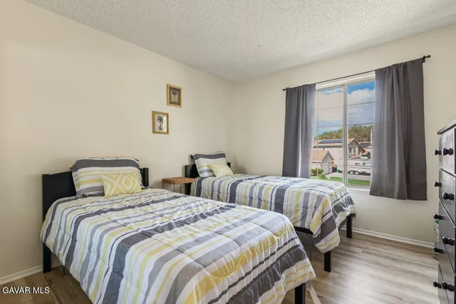 a bedroom with two beds and a large window