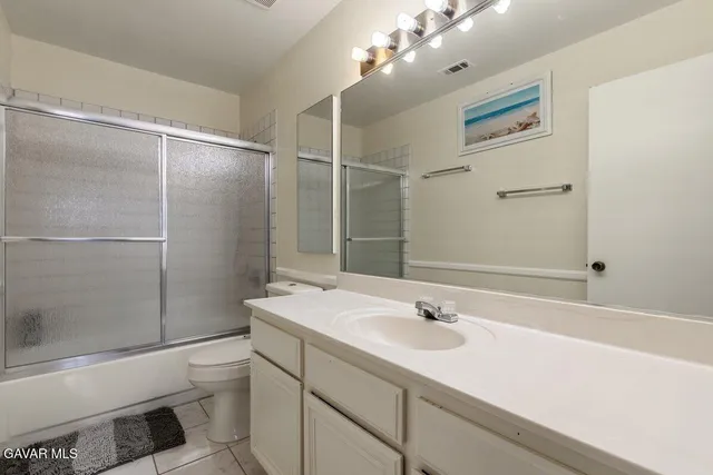 a bathroom with a sink vanity granite toilet and shower