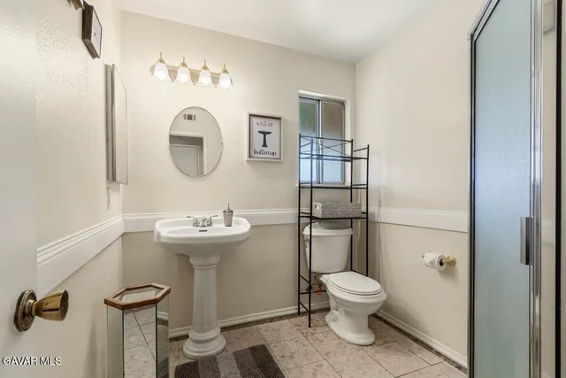a bathroom with a toilet a sink and mirror