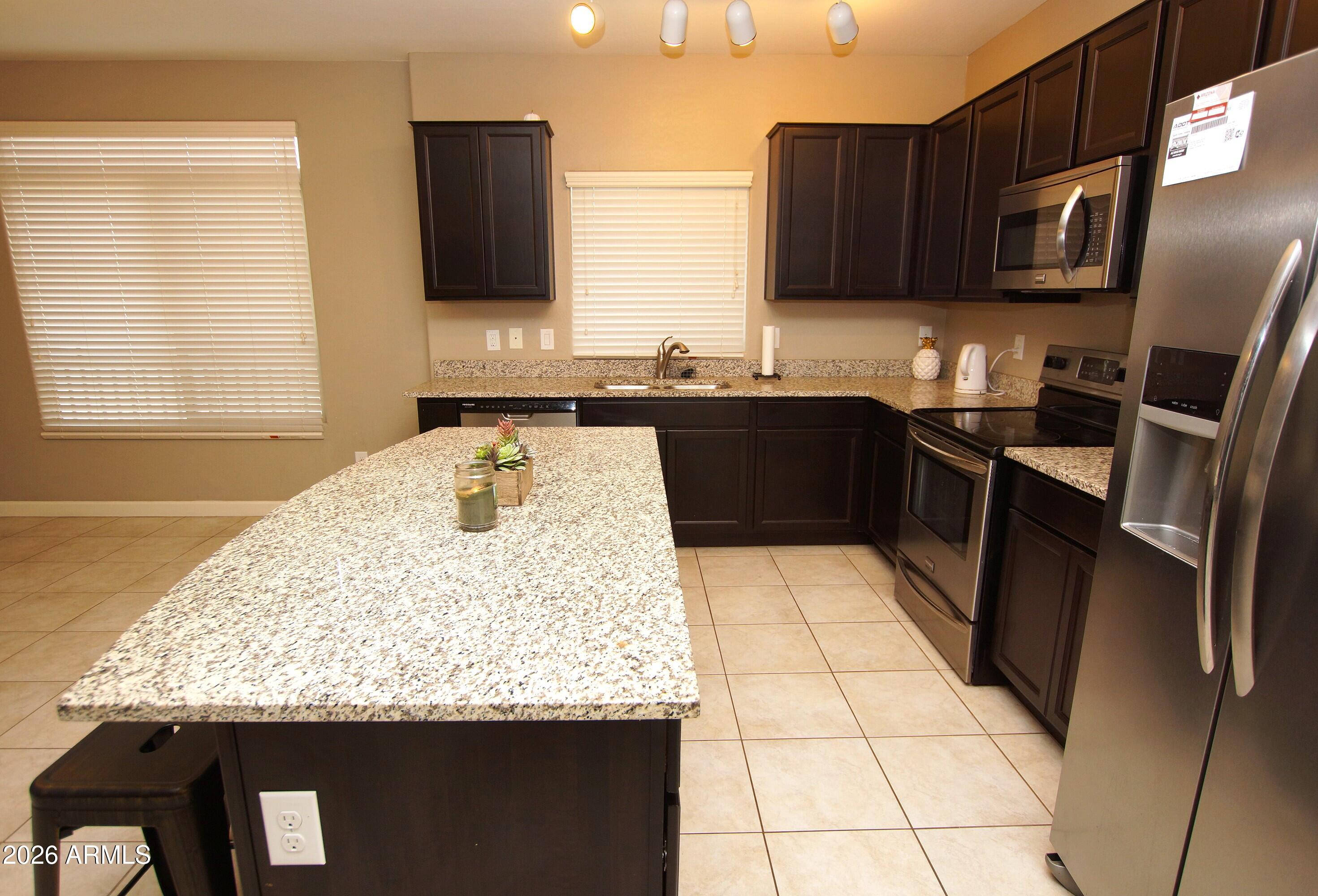 2150 West Alameda Road, Unit 1095 Phoenix, AZ 85085 - Photo 9 of 32 a kitchen with stainless steel appliances granite countertop a sink stove and refrigerator