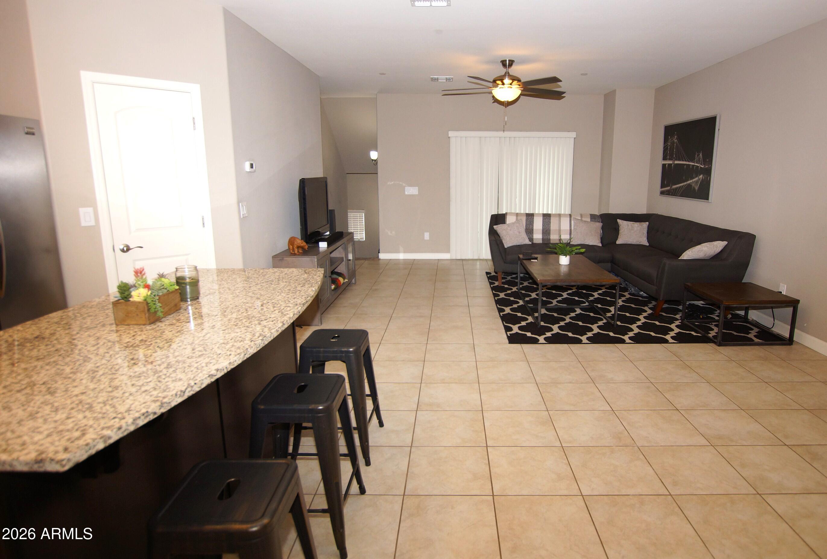 2150 West Alameda Road, Unit 1095 Phoenix, AZ 85085 - Photo 10 of 32 a living room with granite countertop kitchen island furniture and a window