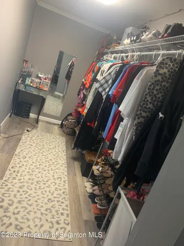 a view of walk in closet with clothes and shoes