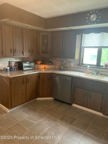 a kitchen with stainless steel appliances granite countertop a sink window and cabinets