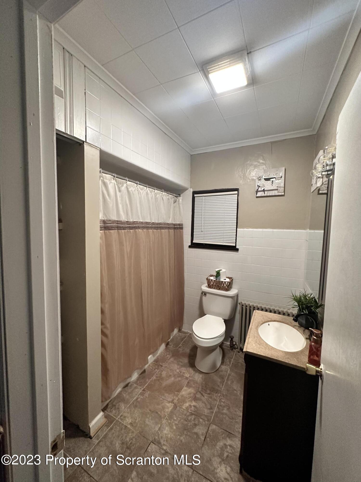 515 Fassold Street Moosic, PA 18507 - Photo 7 of 14 a bathroom with a toilet a sink and a mirror
