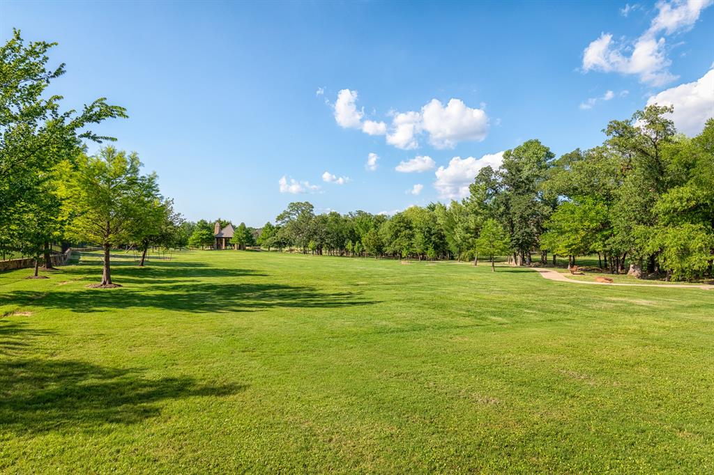 7013 Handel Colleyville, TX 76034 - Photo 36 of 37 Expansive open green space bordered by mature trees and a natural wood fence