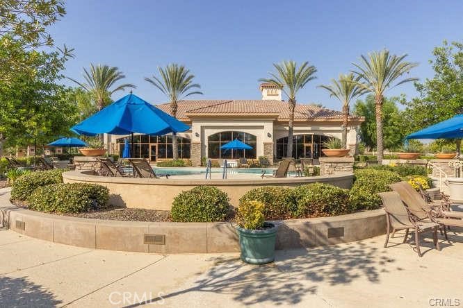 1370 Corte Alamonte Hemet, CA 92545 - Photo 54 of 62 a view of a swimming pool with lawn chairs under an umbrella