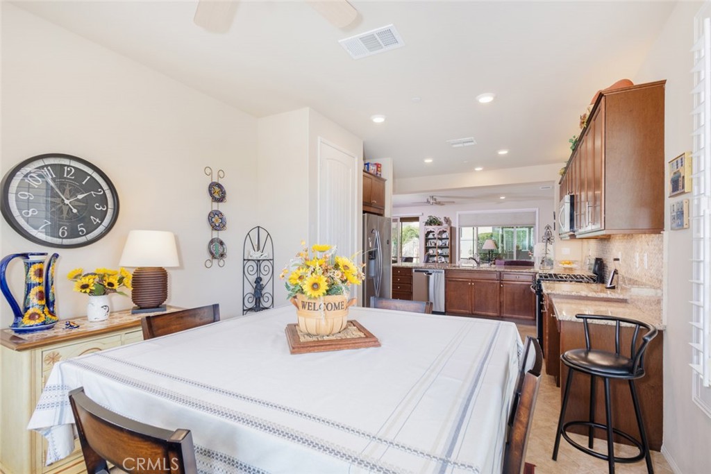1370 Corte Alamonte Hemet, CA 92545 - Photo 10 of 62 a kitchen with a dining table cabinets and a stove top oven