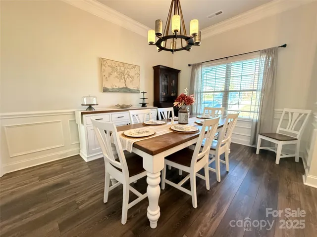 a view of a dining room with furniture wooden floor and chandelier