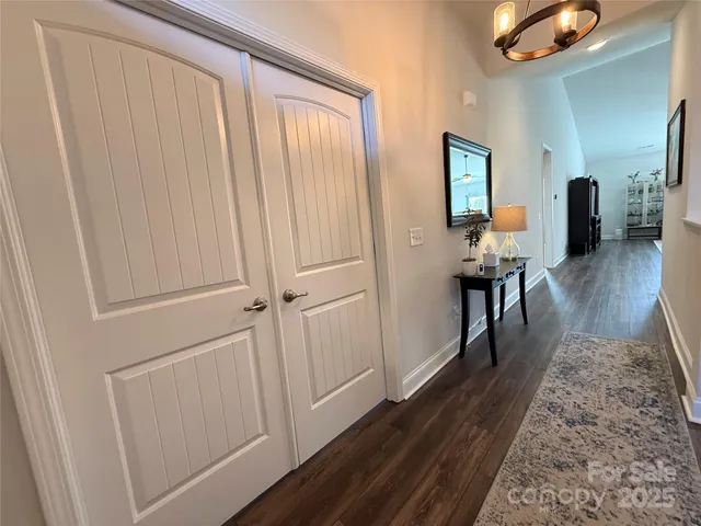 a view of a hallway with wooden floor and furniture