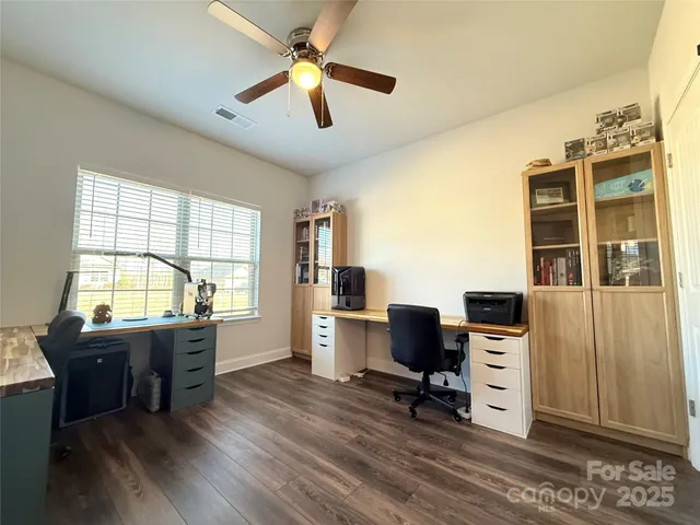a view of a workspace with furniture and a window