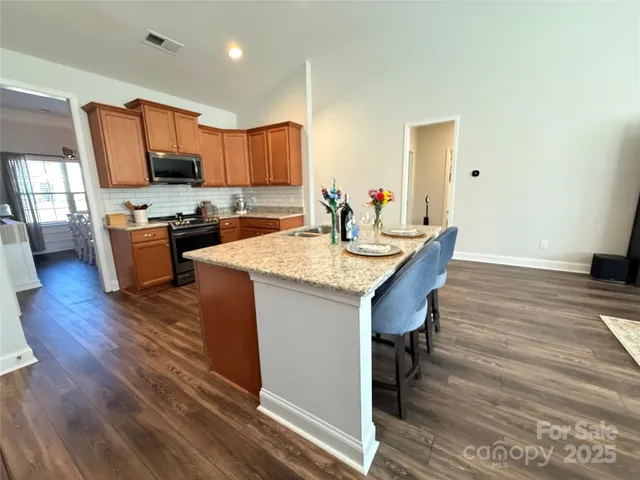 a kitchen with a table chairs refrigerator and a sink