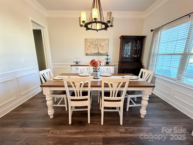 a dining room with furniture a chandelier and wooden floor